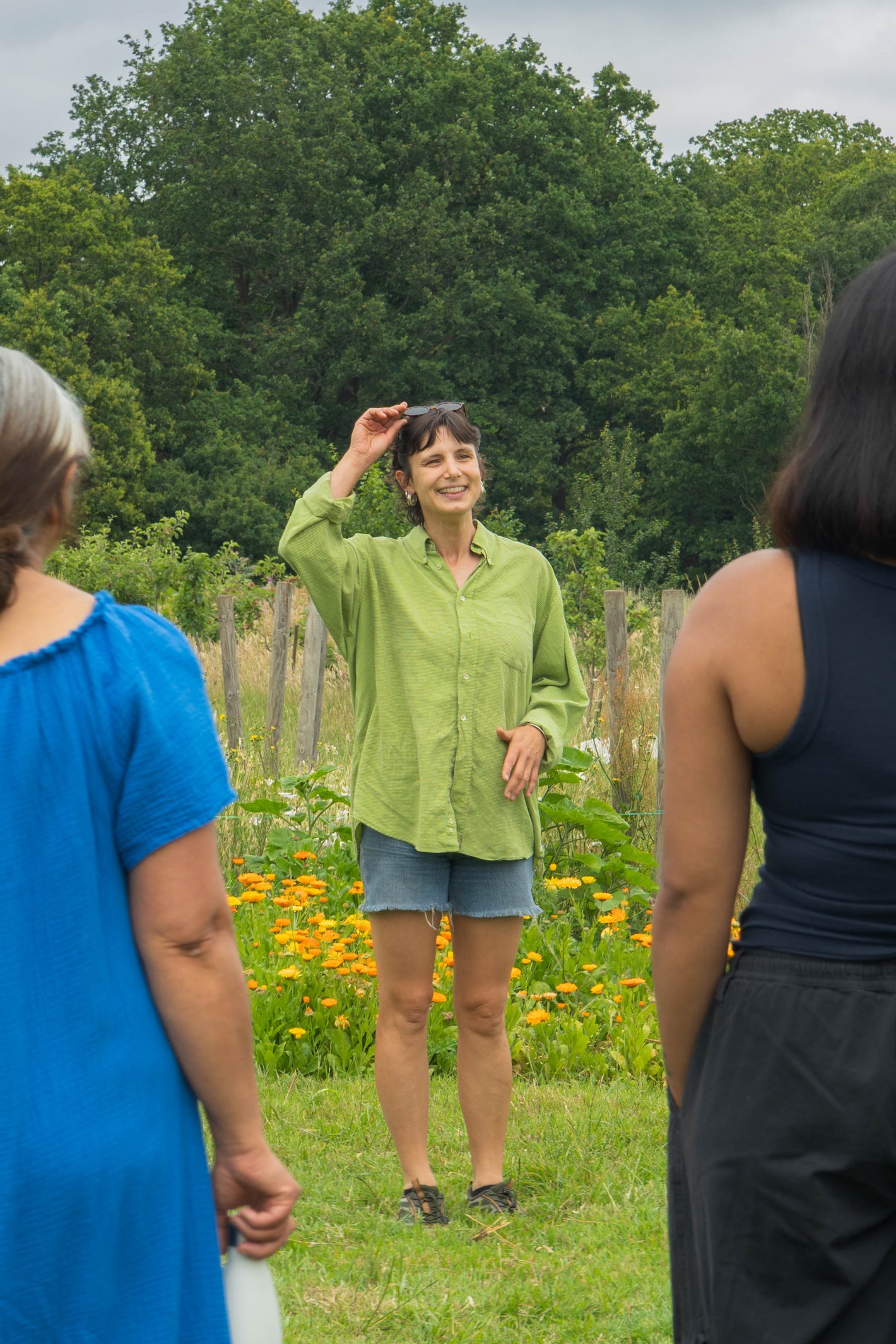 Stevie leading a session in the field with trees in the background